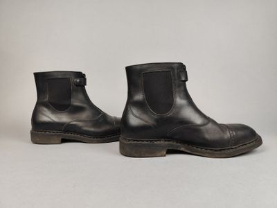 une paire de bottes en cuir noir sur fond blanc