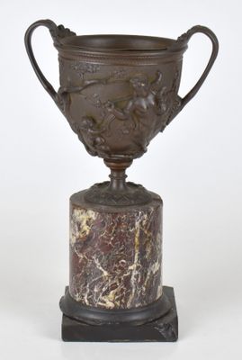 une image représentant un trophée en bronze posé sur un socle en marbre