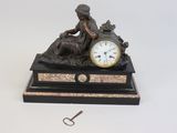 a statue of a woman sitting on a table with a clock