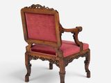 an old wooden chair with a red upholstered seat