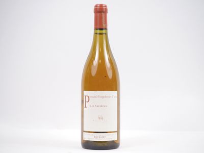 une bouteille de vin blanc posée sur une table blanche