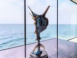 a statue of a fish in a glass case on a table