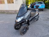 un scooter garé sur un parking à côté d'un immeuble