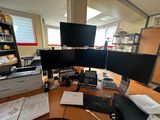 a desk with three monitors and a keyboard on it