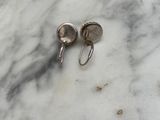a pair of earrings that are on a marble surface