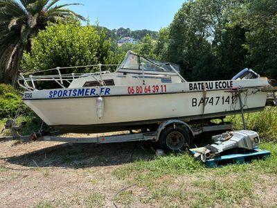 a boat that is sitting on a trailer in the grass