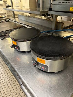 deux poêles à crêpes posées sur une table dans une cuisine