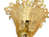 a gold wall light that is hanging on the wall