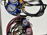 two gauges and a couple of hoses sitting on a table