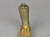 a small metal object with a gold foot on it