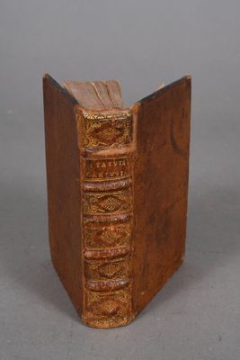 Un vieux livre est posé sur une table, sur fond gris.