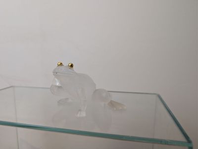 a glass table with a frog figurine on top of it