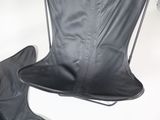 a black leather chair and a black leather boot on a white table