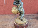 a statue of a boy holding a ball on a table