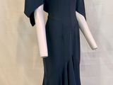 le dos d'une robe noire posée sur un socle de mannequin