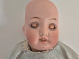 a doll with a bald head sitting on a table