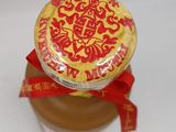 a jar of honey with a red ribbon around it