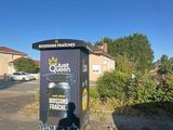 a trash can sitting on the side of the road