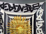 a black and white flag with a gold sun on it