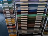 a lot of different colors of paper stacked on a rack
