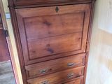 une grande commode en bois dans un coin de la pièce