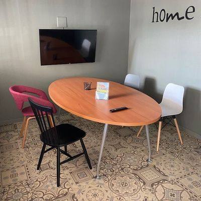 des tables et des chaises dans une pièce équipée d'une télévision à écran plat
