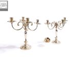 deux chandeliers en argent sur fond blanc, avec un fond blanc