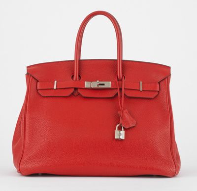 un sac à main en cuir rouge muni d'un cadenas sur la poignée
