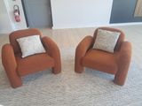 two chairs that are sitting on a rug in a room