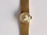 une image d'un gros plan d'une montre-bracelet sur une surface blanche