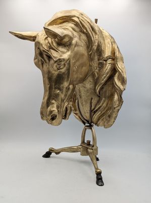 brass horse head sculpture on stand on white background