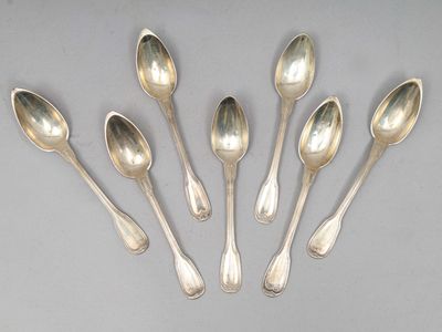 six cuillères en argent sont alignées sur une table