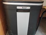 une poubelle noire et blanche à côté d'une étagère en bois