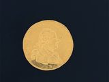 gros plan d'une pièce d'or sur une surface noire