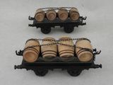 two miniature wooden barrels on a cart on a white surface
