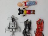 four toy figurines of people on a white surface