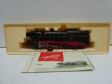 un petit train miniature posé sur une table à côté d'un livret