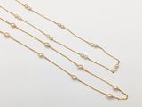 un collier à chaîne en or orné de perles sur fond blanc