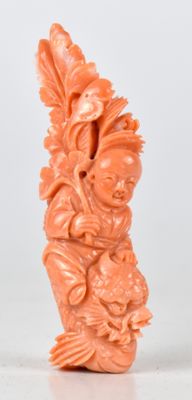 une figurine sculptée de couleur orange posée sur une surface blanche