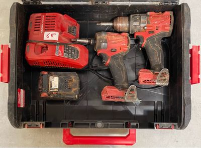 deux outils électriques rouges dans une boîte à outils posée par terre