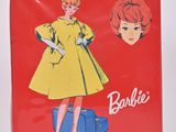 une boîte rouge sur laquelle figure l'image d'une femme en robe jaune