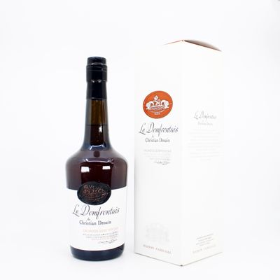 des bouteilles d'alcool posées à côté d'une boîte sur une surface blanche