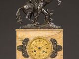 an antique clock with a bronze statue of a man on a horse on a marble base