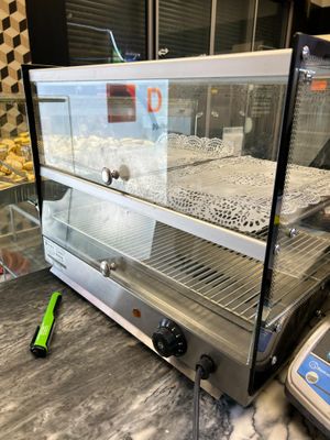 an image of a bakery display case with donuts in it