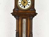 a wooden clock hanging on the wall with a clock on it