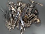 a lot of silver spoons and forks on the table