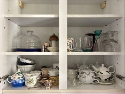 many dishes and cups on the shelves in the kitchen
