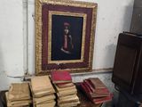 une table sur laquelle sont posés des livres et un tableau accroché au mur