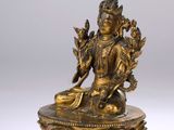 a gold statue of a person sitting on a lotus flower