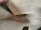 a hand holding a piece of paper that is sticking out of a bag